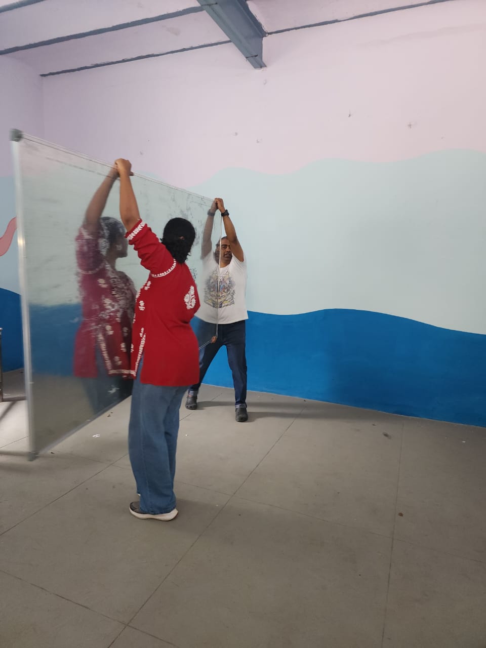 Installing the smart class screen at Mitralaya Girls High School